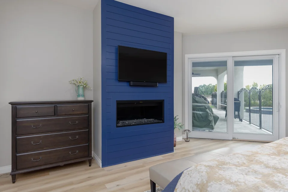 Bedroom fireplace in navy wall cladding beside patio doors