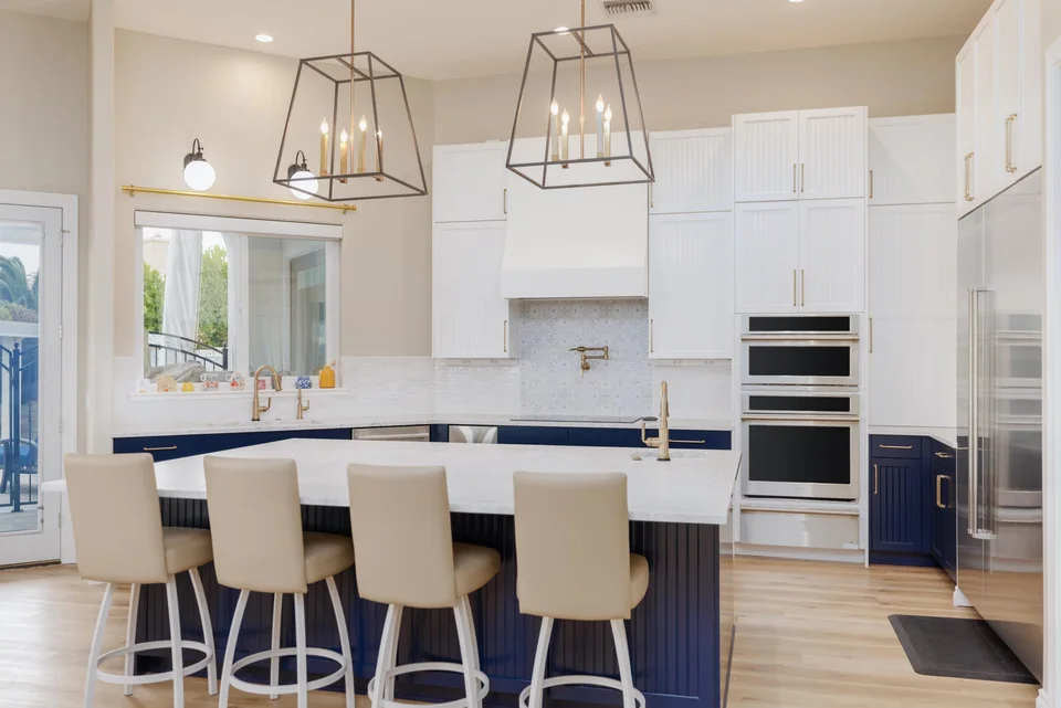 Front view of navy and white kitchen with island seating