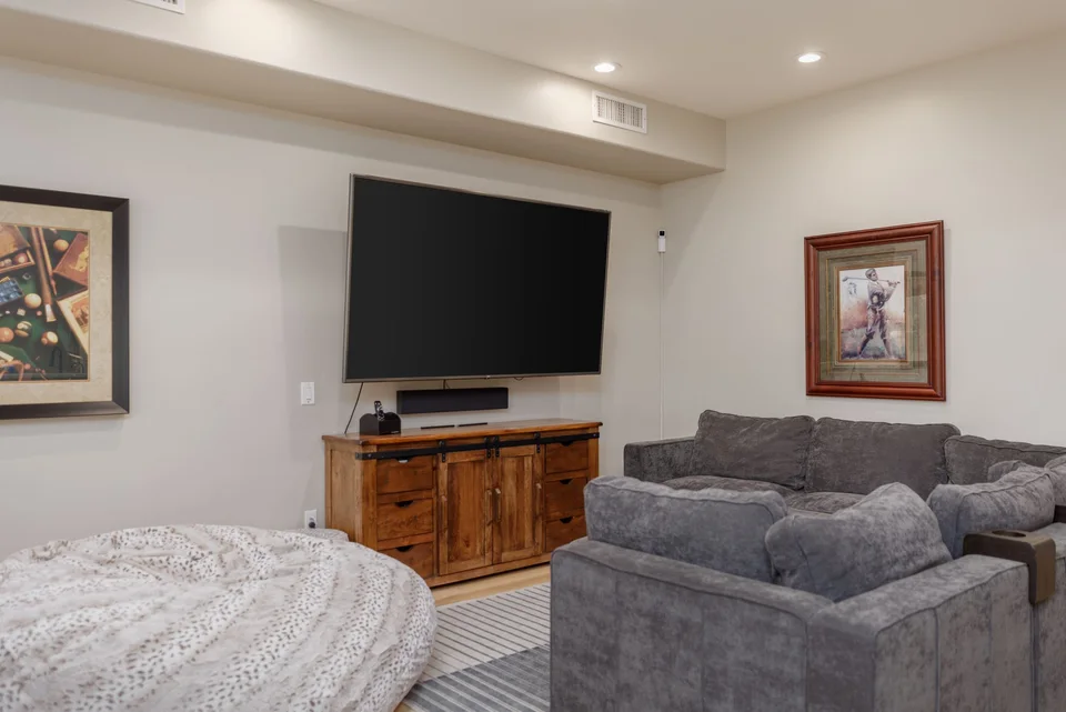 Media room with grey sectional and wall-mounted television