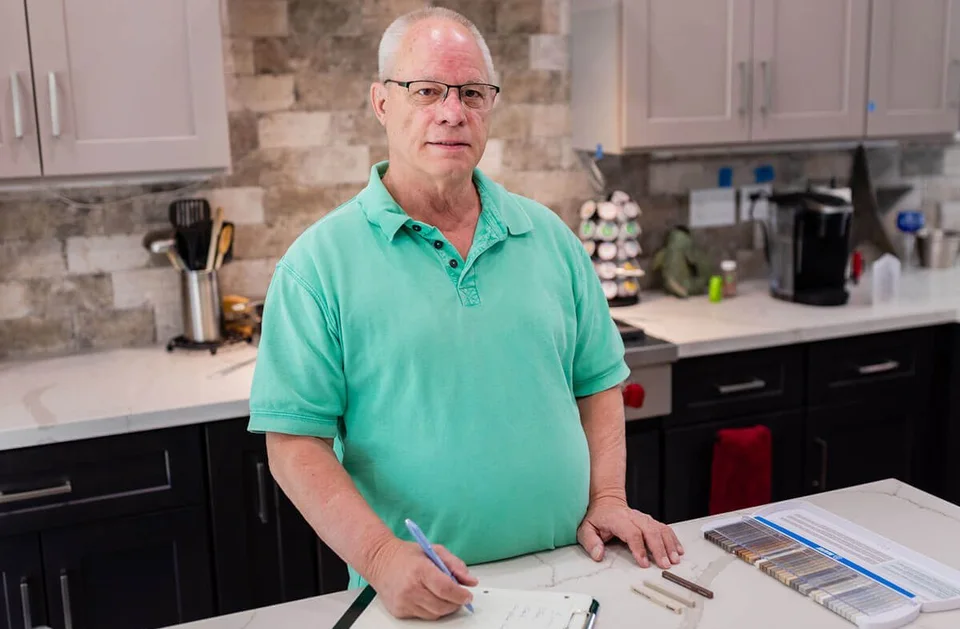 Ernie Merrill beside a countertop with planning materials