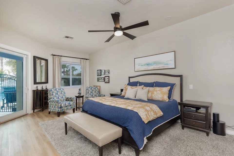 Bedroom with blue bedding, seating and patio doors